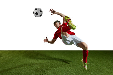 Champion. Young man, professional football player in motion, kicking ball in jump and falling on...
