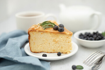 A still life, a piece of blueberry cheesecake and a cup of tea are on the table