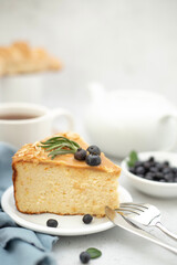 A still life, a piece of blueberry cheesecake and a cup of tea are on the table