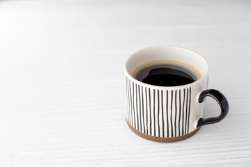 A cup of aromatic hot black coffee on a white background