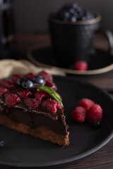 Still life with a piece of chocolate brownie cake with raspberries