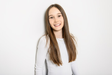 Fototapeta premium Young brunette pre teen girl on studio white