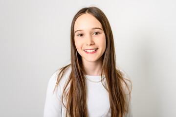 Obraz premium Young brunette pre teen girl on studio white