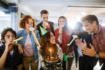 Group of young people celebrating a birthday in the office