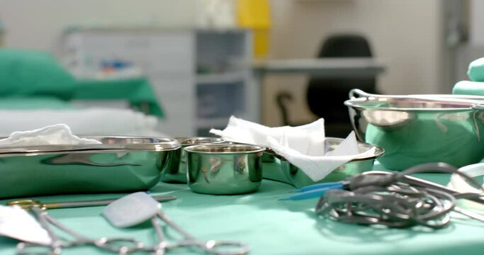 Close up of surgical instruments on table in operating theatre at hospital, slow motion