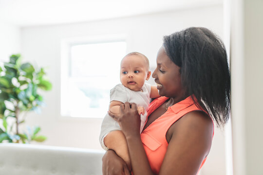 portrait of beautiful young American mother with baby at home