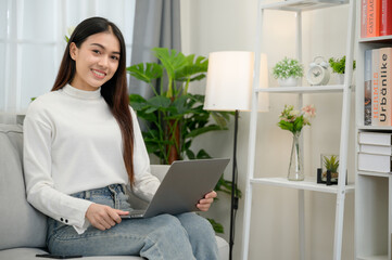 asian girl happy freelancer smiling looking at camera Have a laptop to work at home