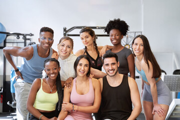 Fototapeta na wymiar multicultural group of fitness people looking at camera and smiling at the gym