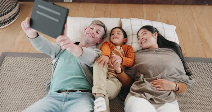 Happy family, tablet and lying on floor for selfie, picture or photo relaxing together in living room at home. Father, child and mother in relax with technology and smile for memory or bonding time