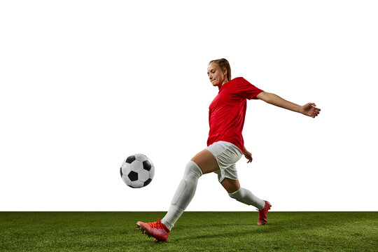 Dynamic image of female athlete, young girl, football player in motion with ball on sports field against white background. Concept of professional sport, action, lifestyle, competition, training, ad