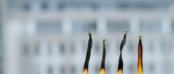 burnout, modern workplace, hustle culture concept with burnt down matches and office building in...