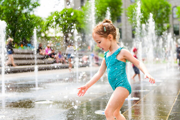 Adorable little girl have fun on hot sunny summer day