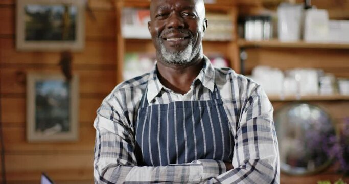 Portrait of happy senior african american male shopkeeper at health food shop, slow motion