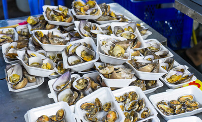 Vietnamese stewed seashells in sauce in the night market on food festival