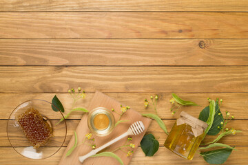 Linden honey with leaves and flowers on wooden backgroung, top view
