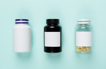 Plastic bottles with vitamins on color background, top view