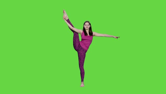 Young graceful woman stretching doing splits standing on green background, Chroma key