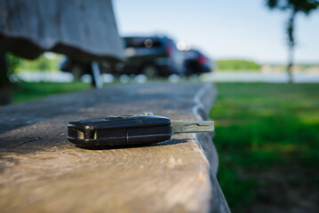 Abandoned,Forgotten car key on a wooden plank on a bench at summer park.Selective focus.