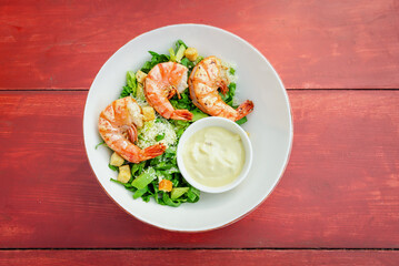 Shrimp Salad. Healthy Seafood Caesar Salad with prawns on the wooden table.top view.