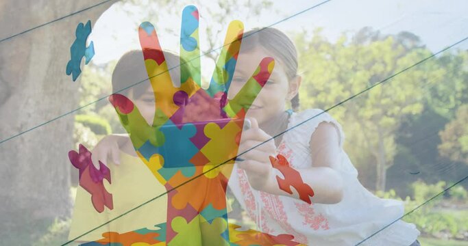 Animation of puzzle pieces forming hand over caucasian children using cellphone