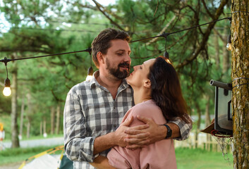 Young married couple kissing and standing in the forest in the evening
