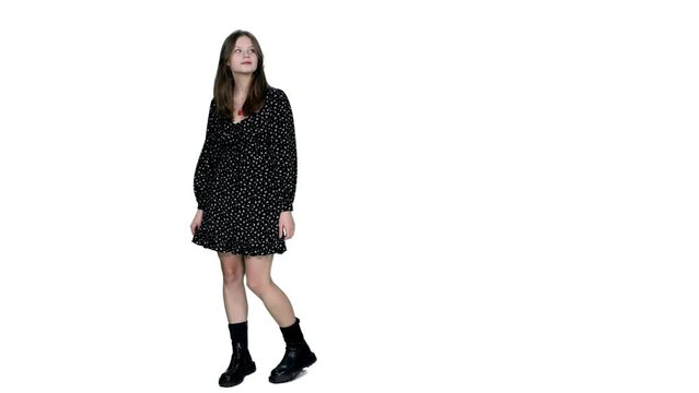 Young adult stylish girl in short polka dot dress and boots watching at something, Full HD footage with alpha transparency channel isolated on white background