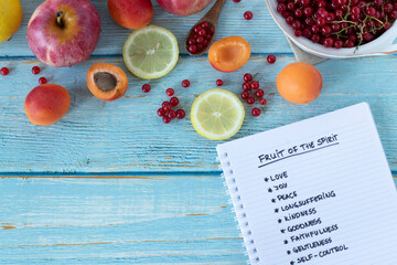 Fruit of the Spirit handwritten words in notebook from Galatians Bible Book on wooden table with...