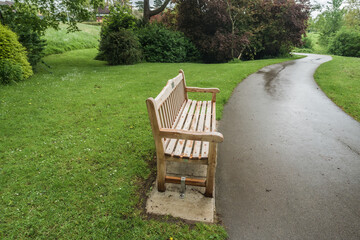 Wide angle view of a wooden park bench with pathway, travel and tourism concept illustration.