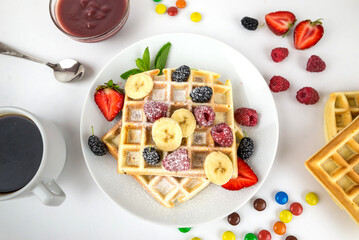 Fototapeta na wymiar Square Belgian waffles with berries and jam on a light white background.