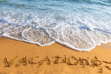 Fototapeta premium Vacation inscription on sandy beach