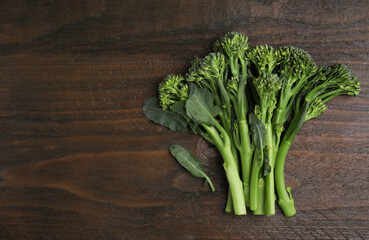 Fresh raw broccolini on wooden table, flat lay and space for text. Healthy food