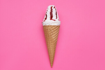 Delicious ice cream with raspberry jam in waffle cone on pink background, top view