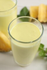 Obraz na płótnie Canvas Tasty pineapple smoothie on white table, closeup