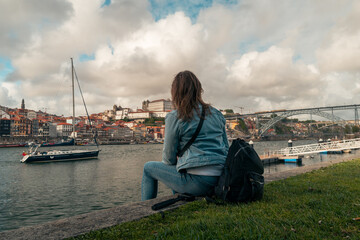 Girl enjoying panoramic view of city landscape, famous bridge and Douro river of Oporto- Portugal. Porto travel destination, magazine concept, selective focus