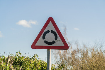 Triangle UK roundabout sign against blue sky with clouds, information, travel and tourism concept...