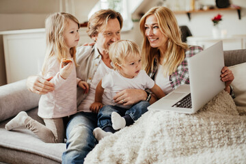 Young family using a laptop at home together