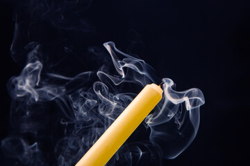 Smoke from an extinguished candle on a dark background. The concept of spirituality and the end of...