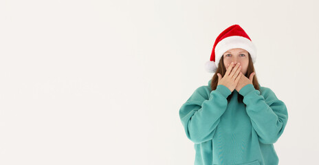 Surprised christmas pregnant girl wearing a santa hat isolated on white background