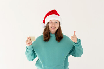 Fototapeta na wymiar Happy woman in Santa hat with credit card on white background