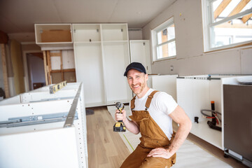 Carpenter Installing Luxury Modern Fitted Kitchen in house