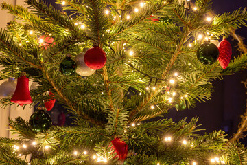 Christmas tree with green and white balls, red bell and a chain of lights