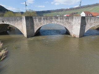 Fototapeta na wymiar old, stone round arch bridge over the river Kocher near Ingelfingen, drone shoot, Germany