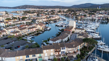 Fototapeta na wymiar Port Grimaud harbor in France in springtime with yachts and sailboats and Mediterranean Sea in the evening, drone shot, Cote d'Azur