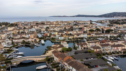 Fototapeta na wymiar Port Grimaud harbor in France in springtime with yachts and sailboats and Mediterranean Sea by day, drone shot, Cote d'Azur