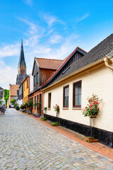 Fototapeta na wymiar Historic houses and church in Holm fisher village of the town Schleswig in Schleswig-Holstein, Germany