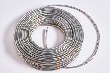 The rolled-up gray cable is a close-up. Abstract technological texture of the background.