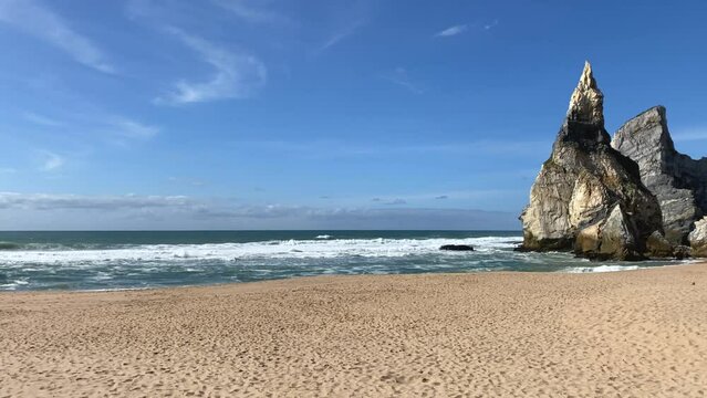 An empty wild sandy beach, Atlantic Ocean seascape, sea waves, beautiful cloudscape, dramatic landscape, travel content, Lisbon, Portugal