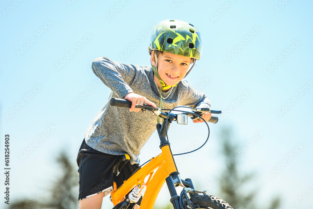 Wall mural child having fun outdoors driving bike for children on playground