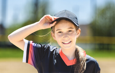 Young girl play baseball on summer day