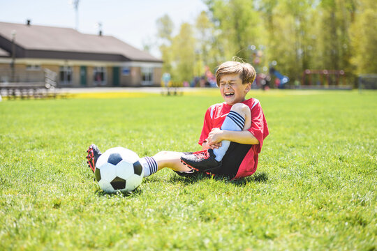 Little Boy play foot on summer day having ankle injury